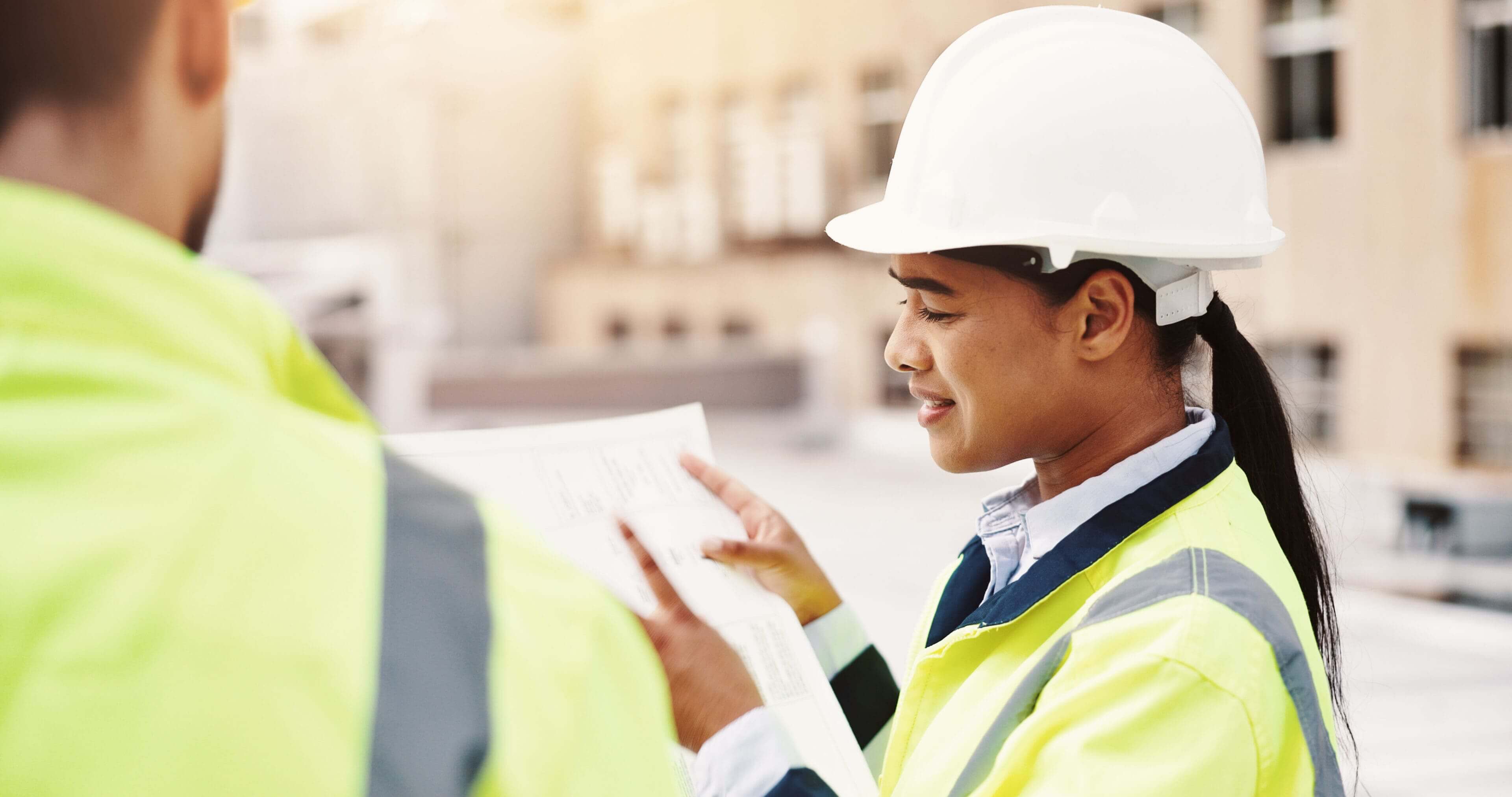 Engineer reviewing blueprints at a construction site.