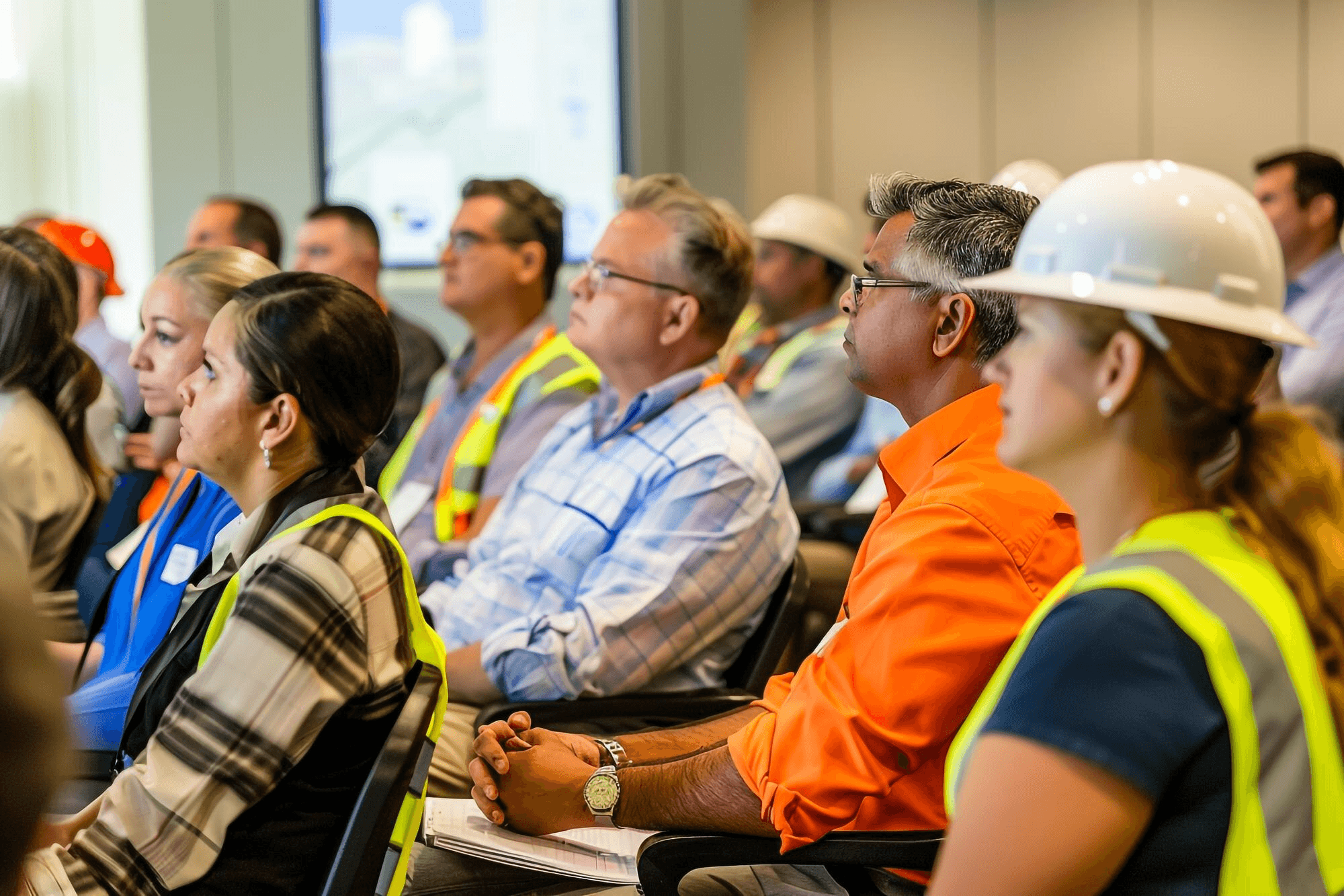 Attentive professionals in safety gear at a training session.