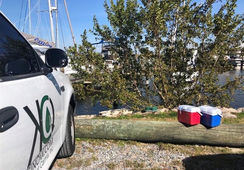 Police car and picnic setup near a lake on a sunny day.