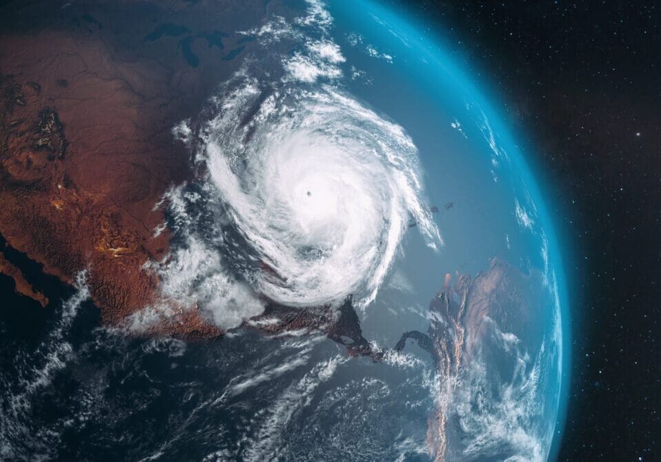 A massive hurricane swirling over the ocean near a coastline.