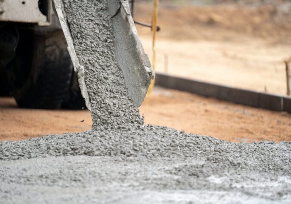 Wet concrete being poured at a construction site.