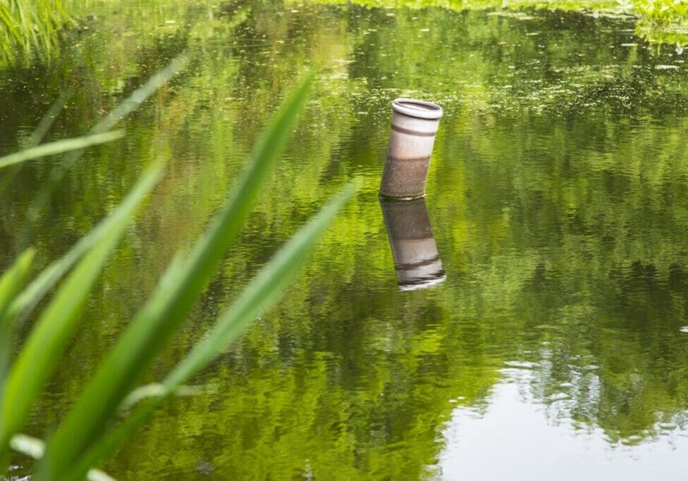 A serene river scene with reflections and greenery.