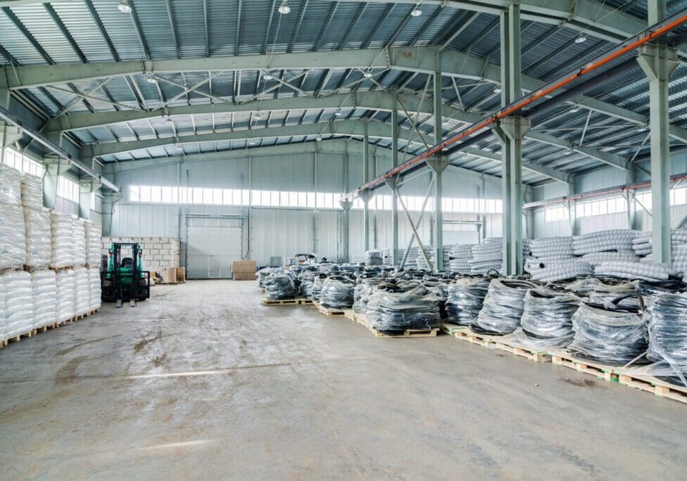 Industrial warehouse interior with stacked materials and machinery.