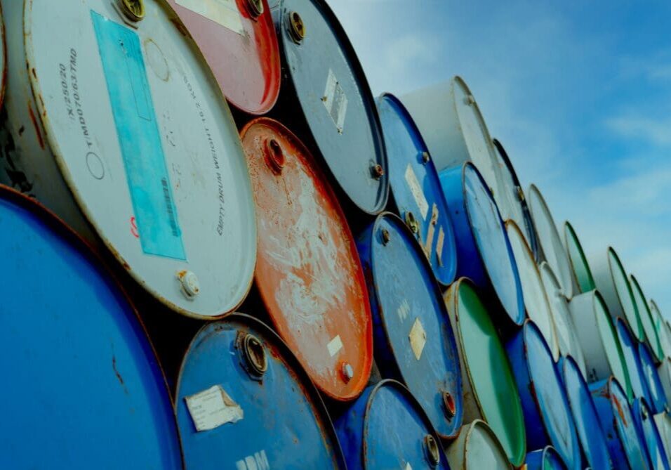 Stacked colorful barrels arranged outdoors under a blue sky.