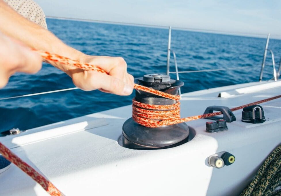 Boat winch with rope coiled around it on a sunny day.