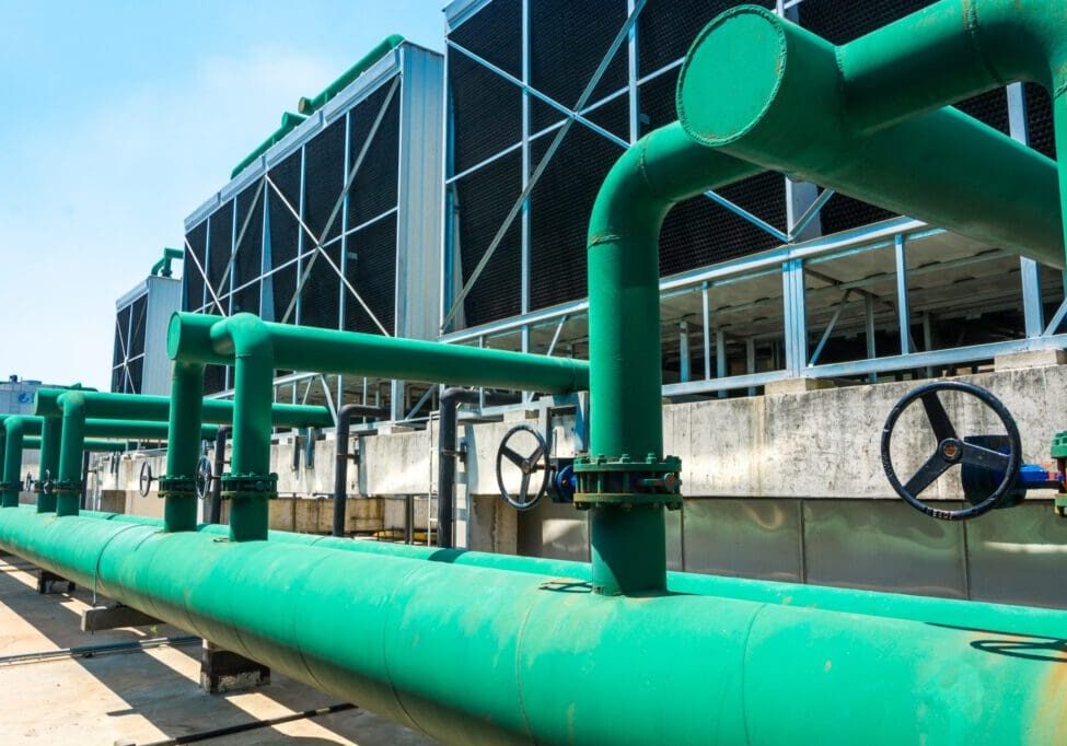 Large green industrial pipes outside a facility.