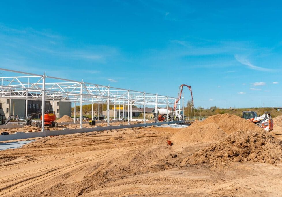Construction site with steel framework and clear blue sky.