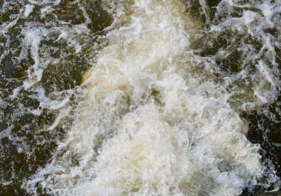 Turbulent white water rapids flowing energetically.